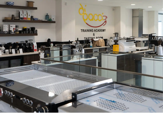 Professional coffee training facility with multiple espresso machines and brewing equipment arranged on countertops.